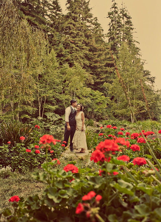 bride and groom in field of red flowers
