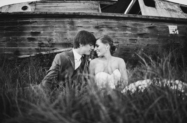bride and groom in front of boat