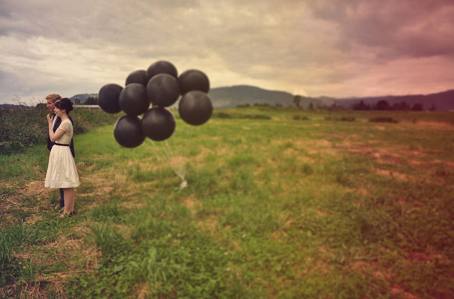 bride and groom with black balloons