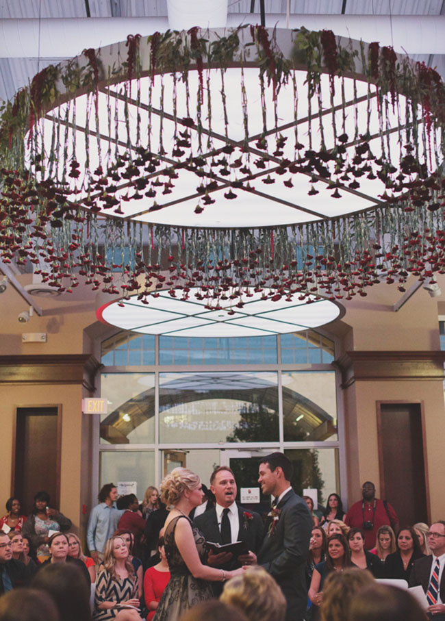 wedding ceremony with flowers hanging from ceiling