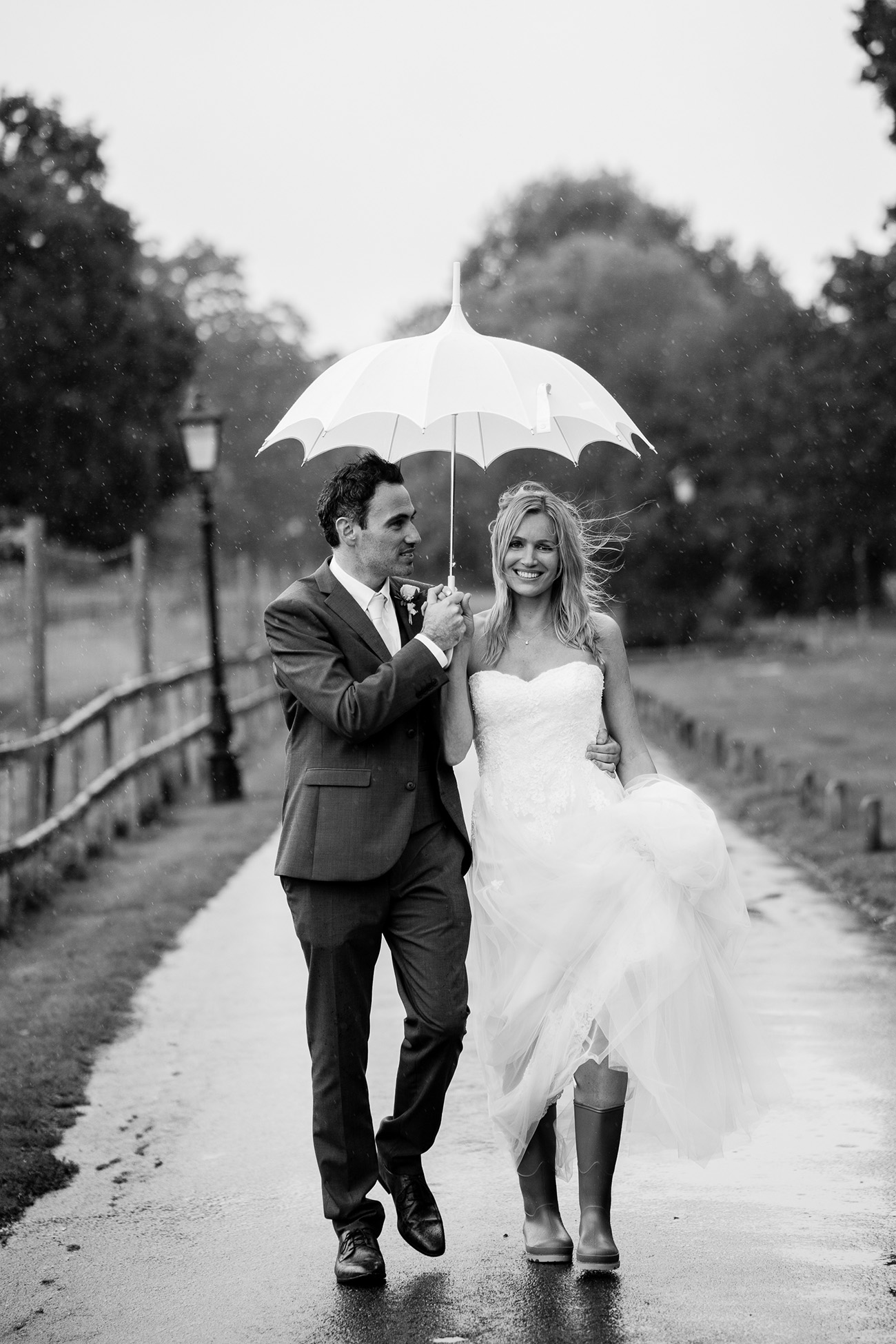 bride in rain boots with vintage umbrella