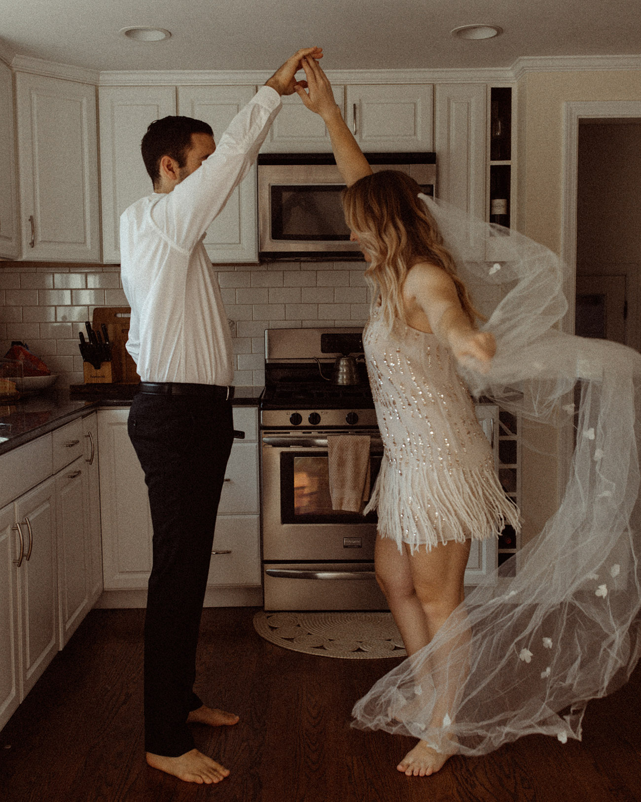bride and groom dancing in their kitchen