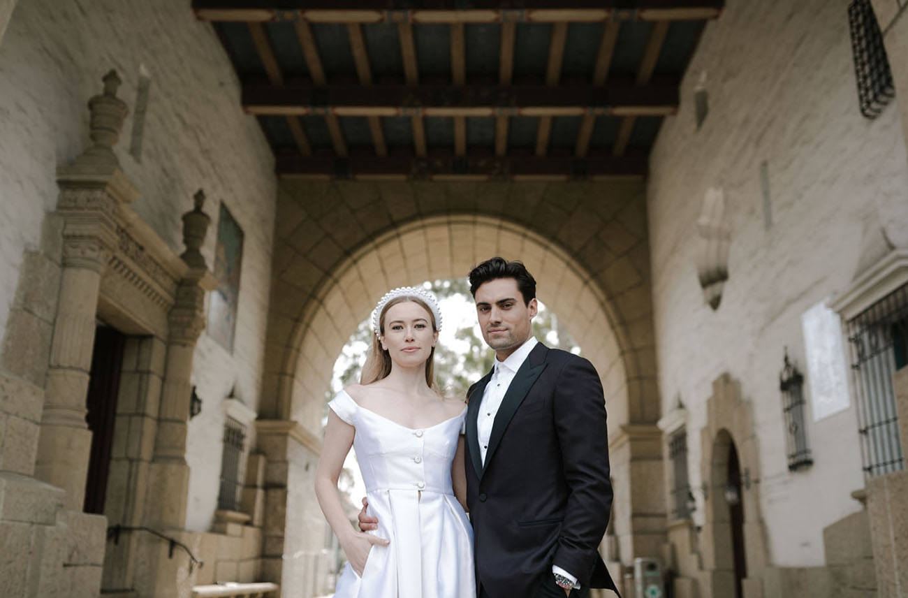 bride and groom with headband in historic arched building
