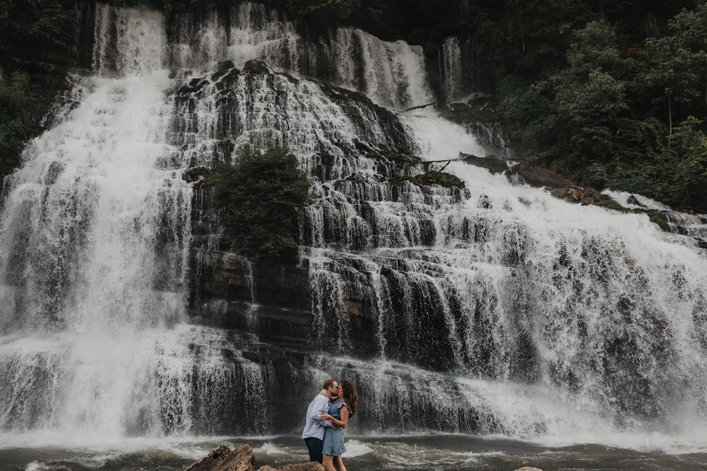 couple standing at the base of a waterfall near Chattanooga Tennessee