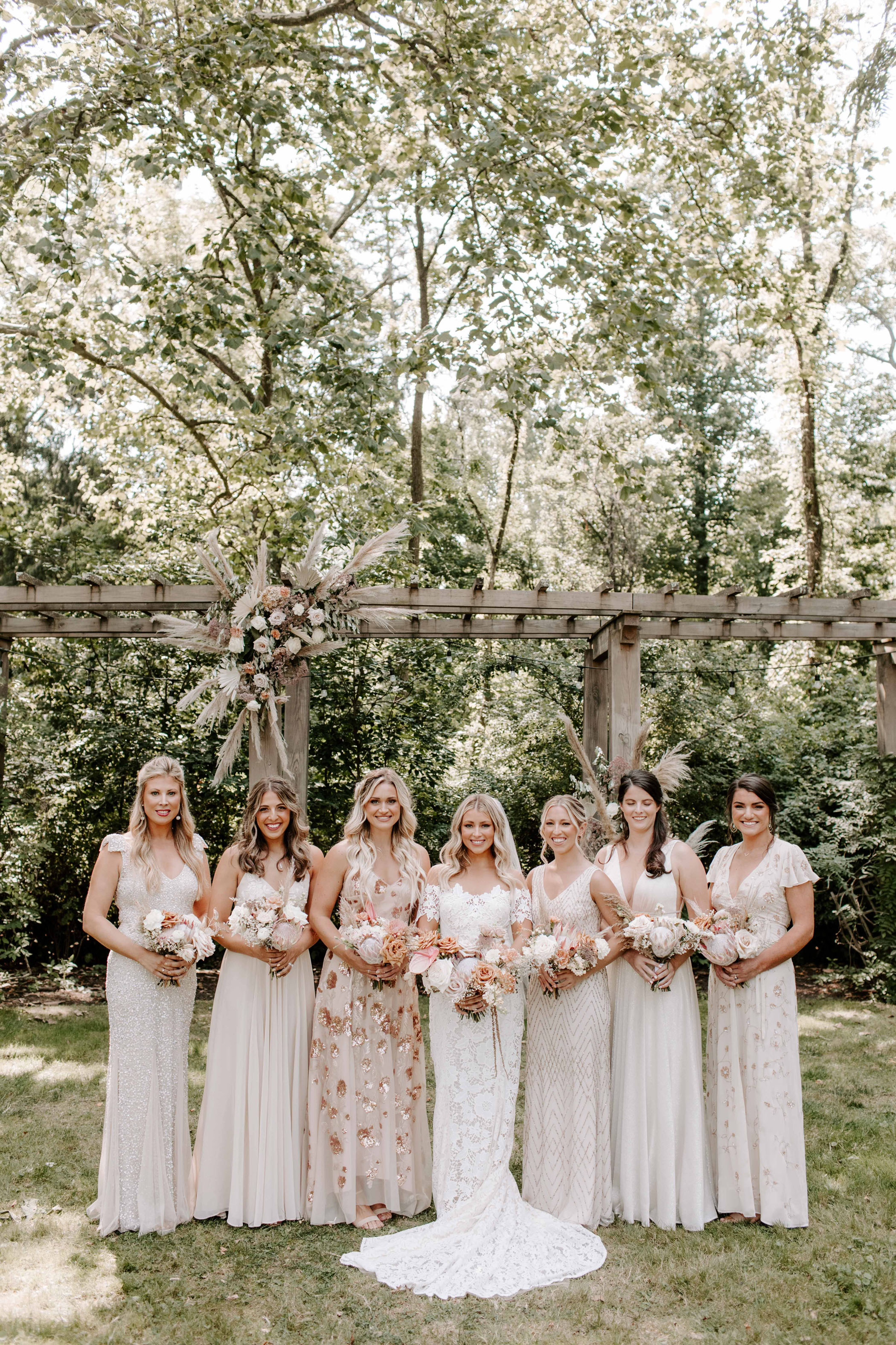 Brides and bridesmaids posing in blush and champagne dresses
