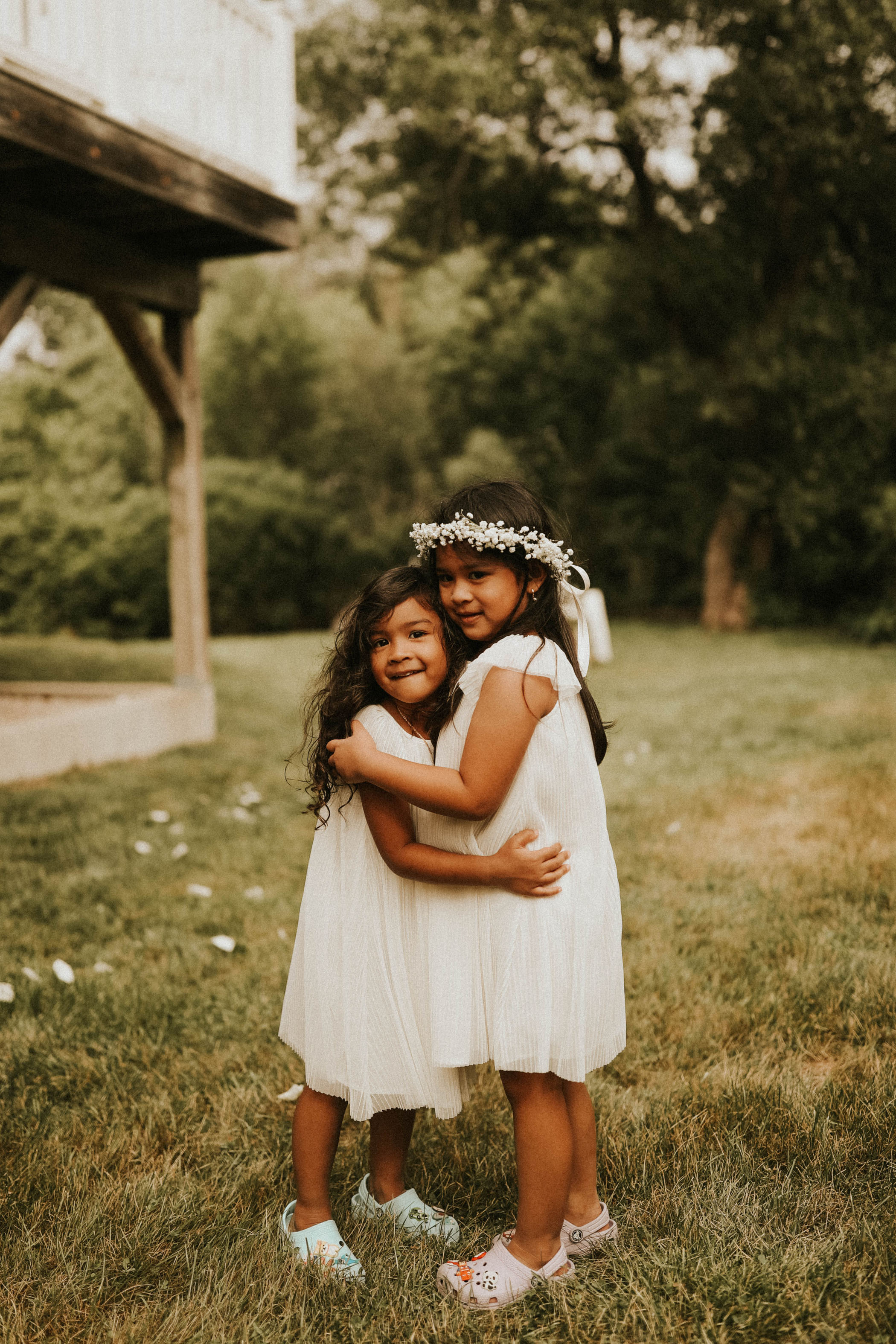 Flower girls hugging during their parent's elopement