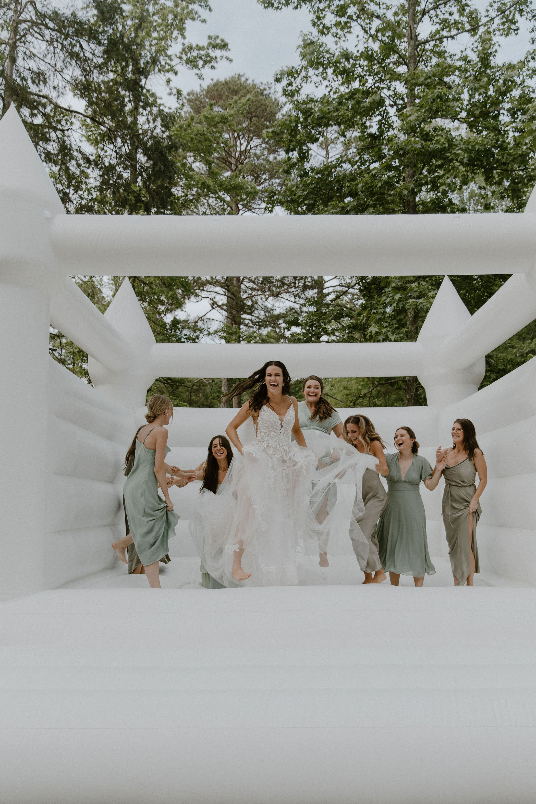 Bride and her bridesmaids in a white bouncehouse
