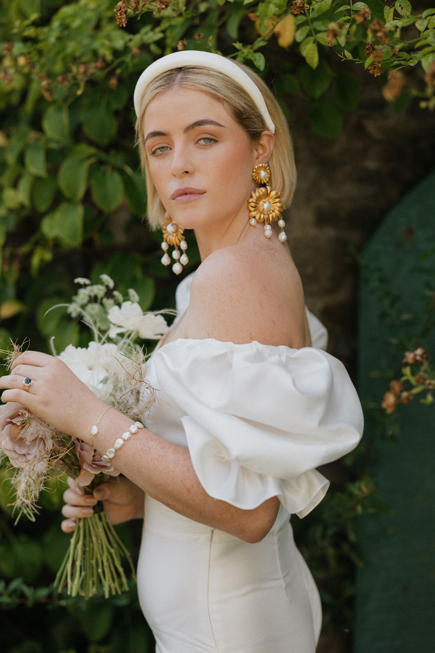 bride with short hair and white headband and dangling earrings