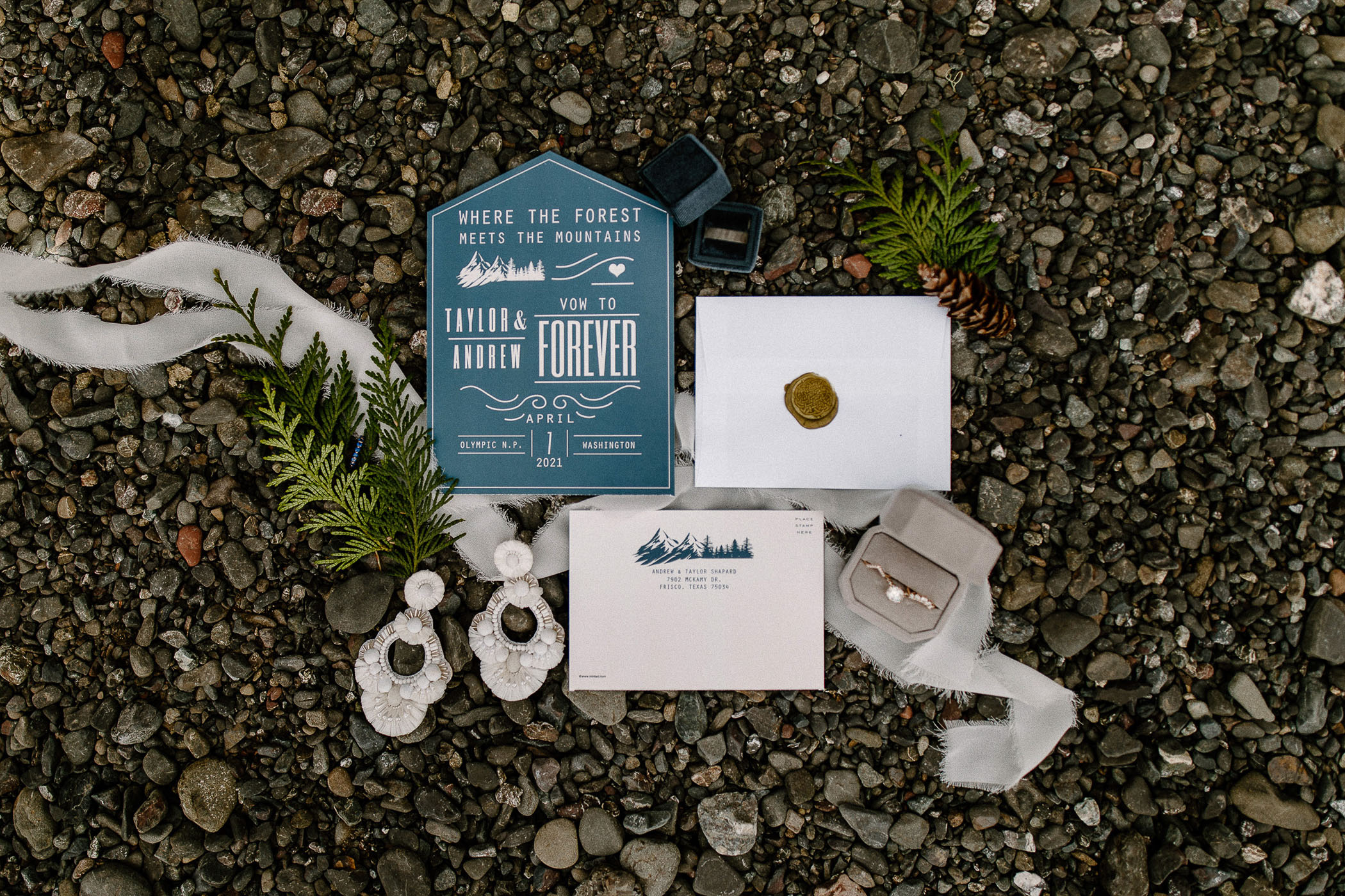 Blue and white wedding invitations on gravel