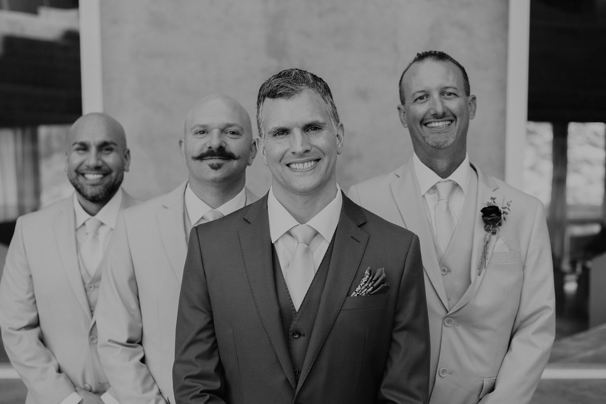 black and white photo of groom and groomsmen smiling