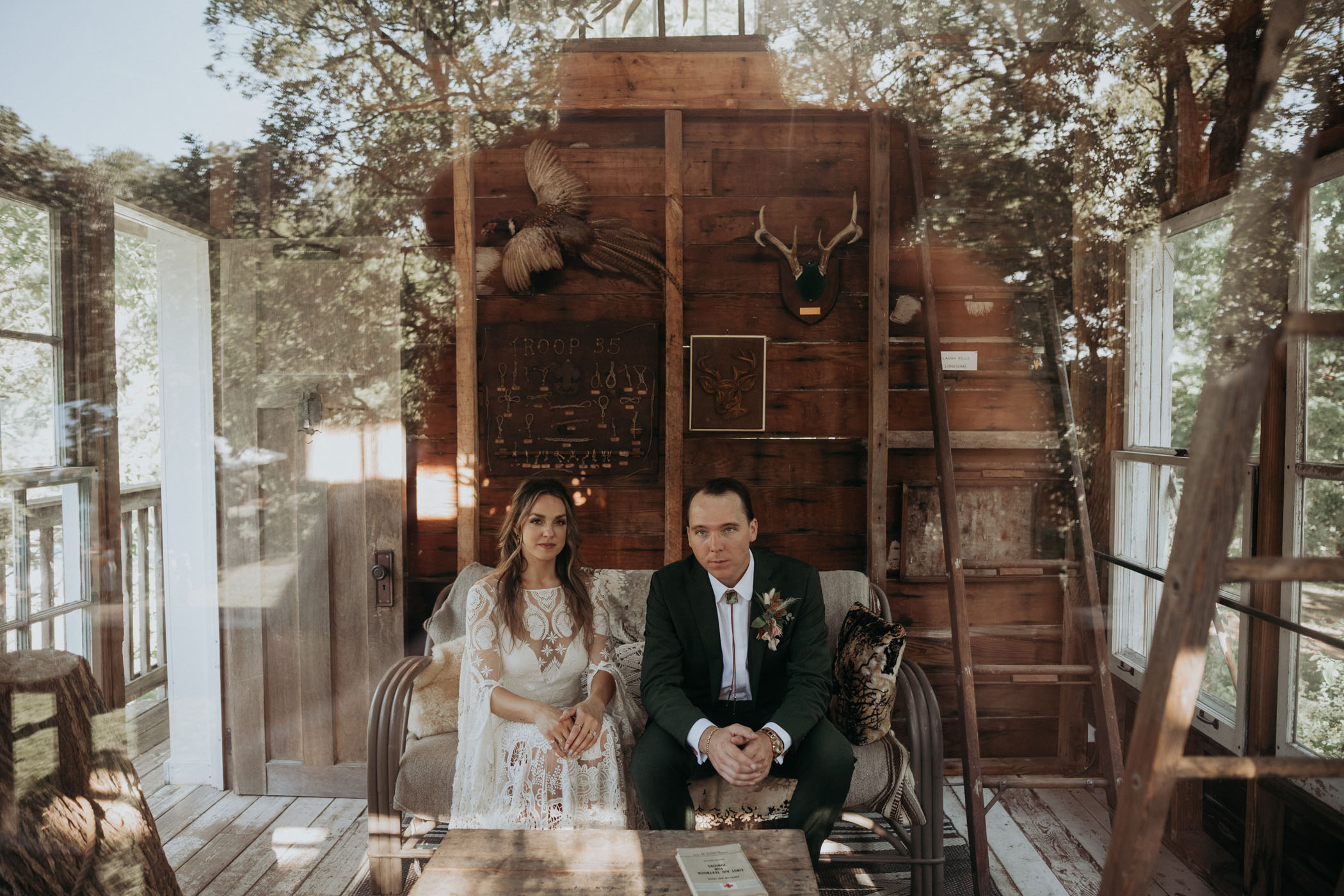 Bride and groom posing inside of a cabin