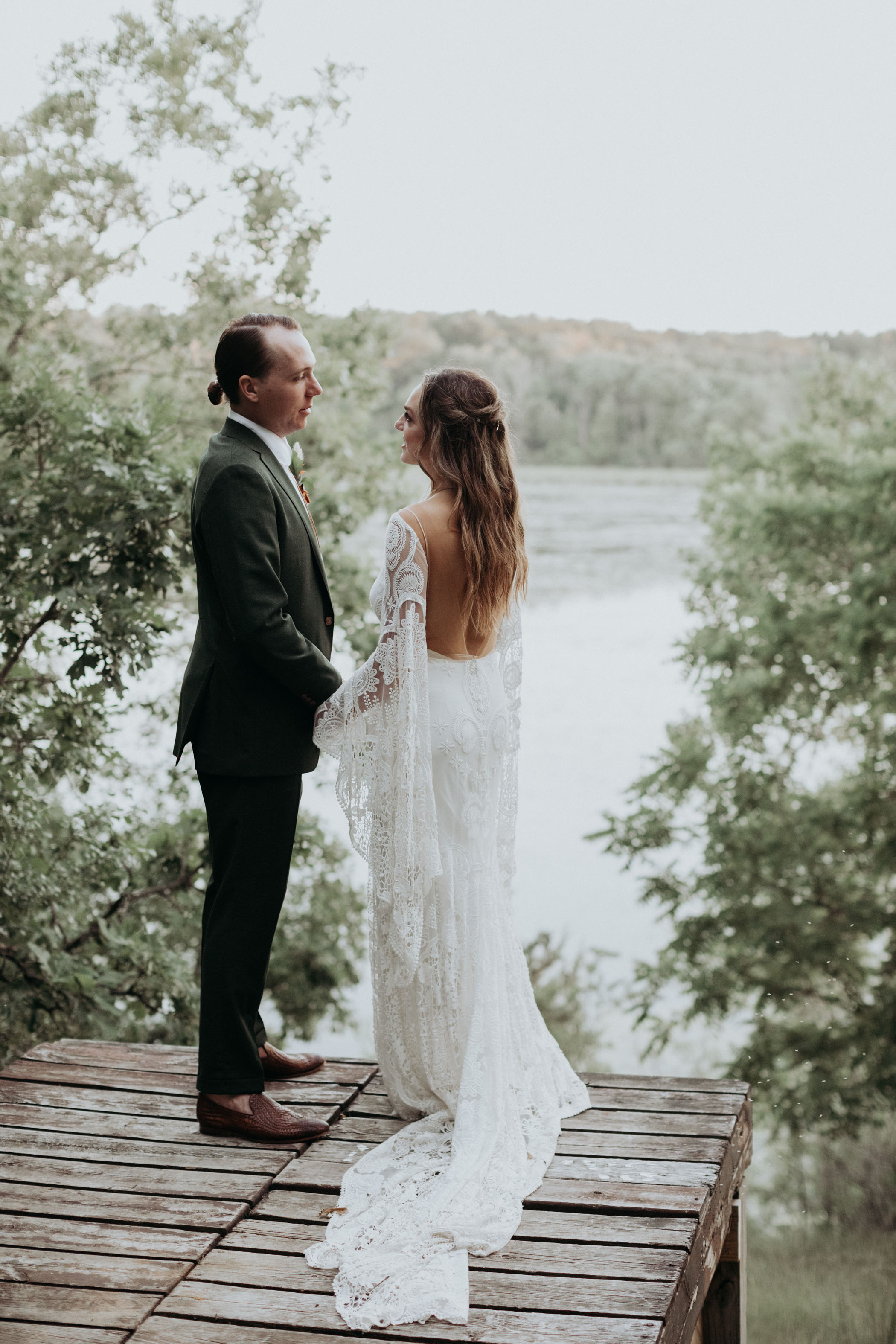 Bride and groom looking at each other lovingly on a dock