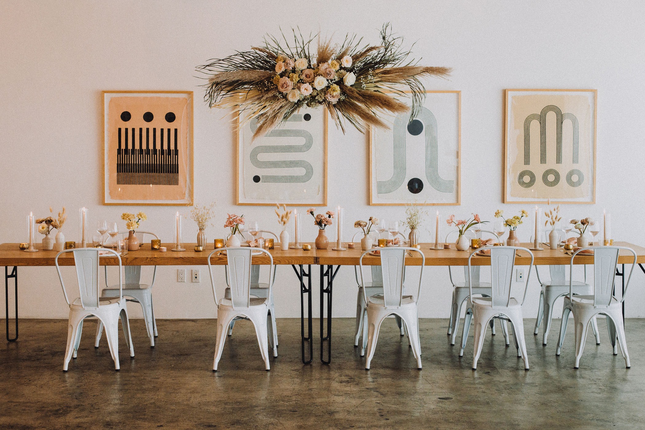 wedding reception table with floral installation and framed line art on the walls