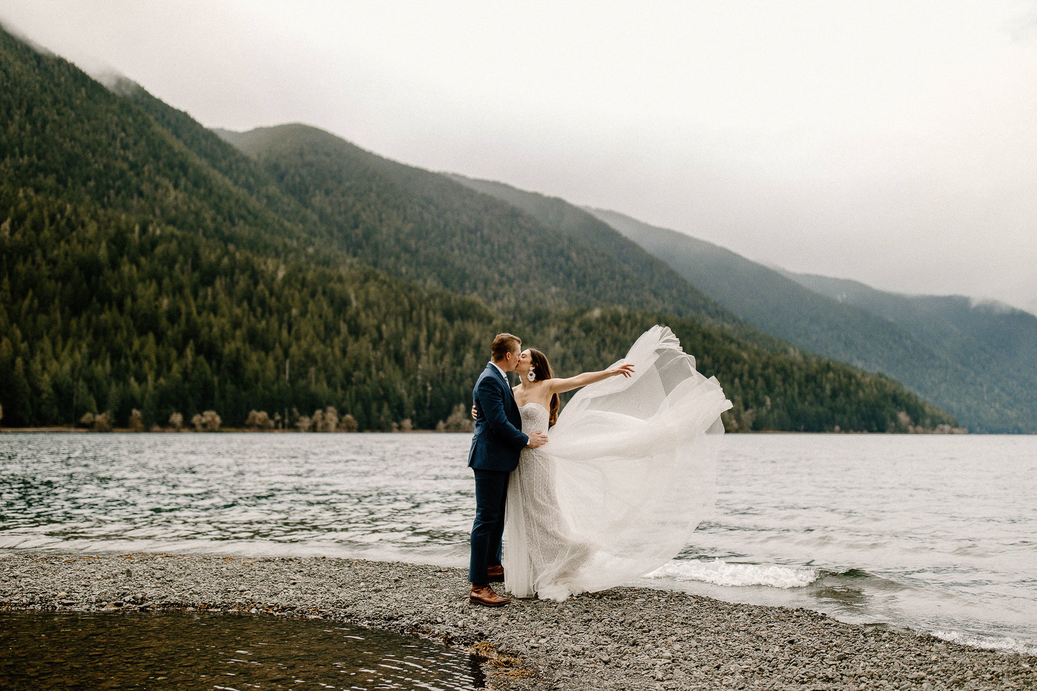 bride's dress flowing in the wind along a lake