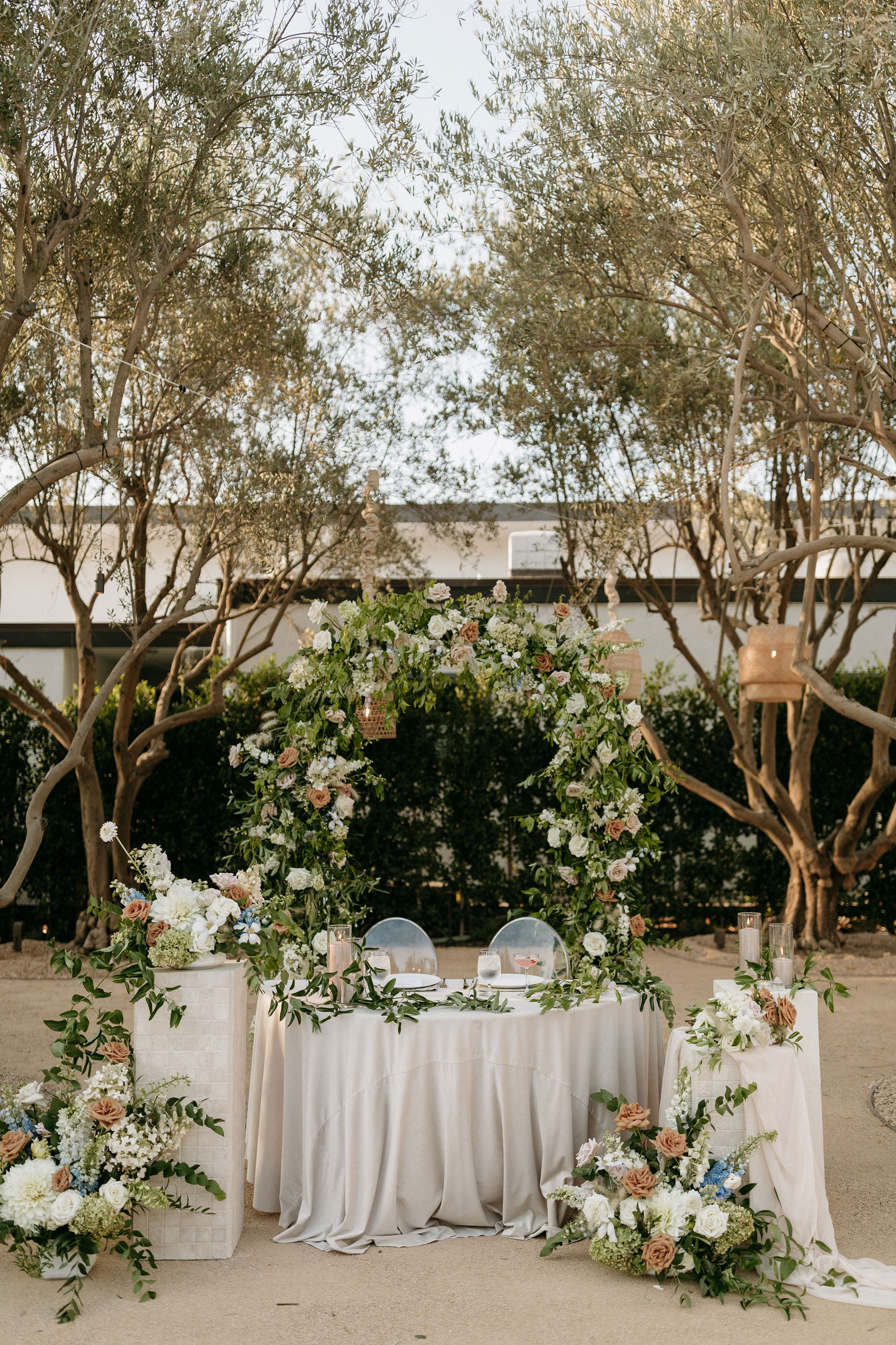 sweetheart table with floral and greenery arch