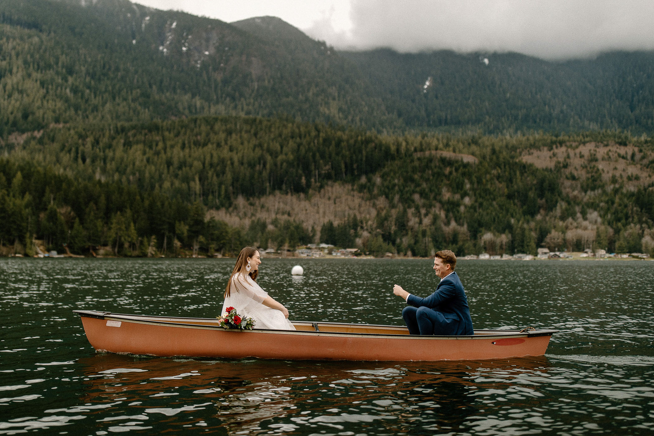 bride and groom canoeing on a lake