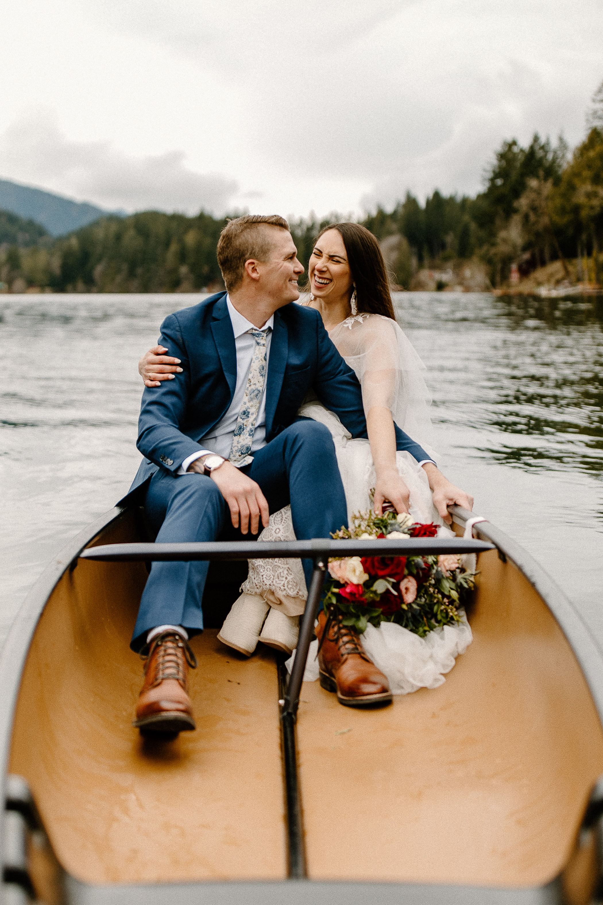 bride and groom canoeing on a lake