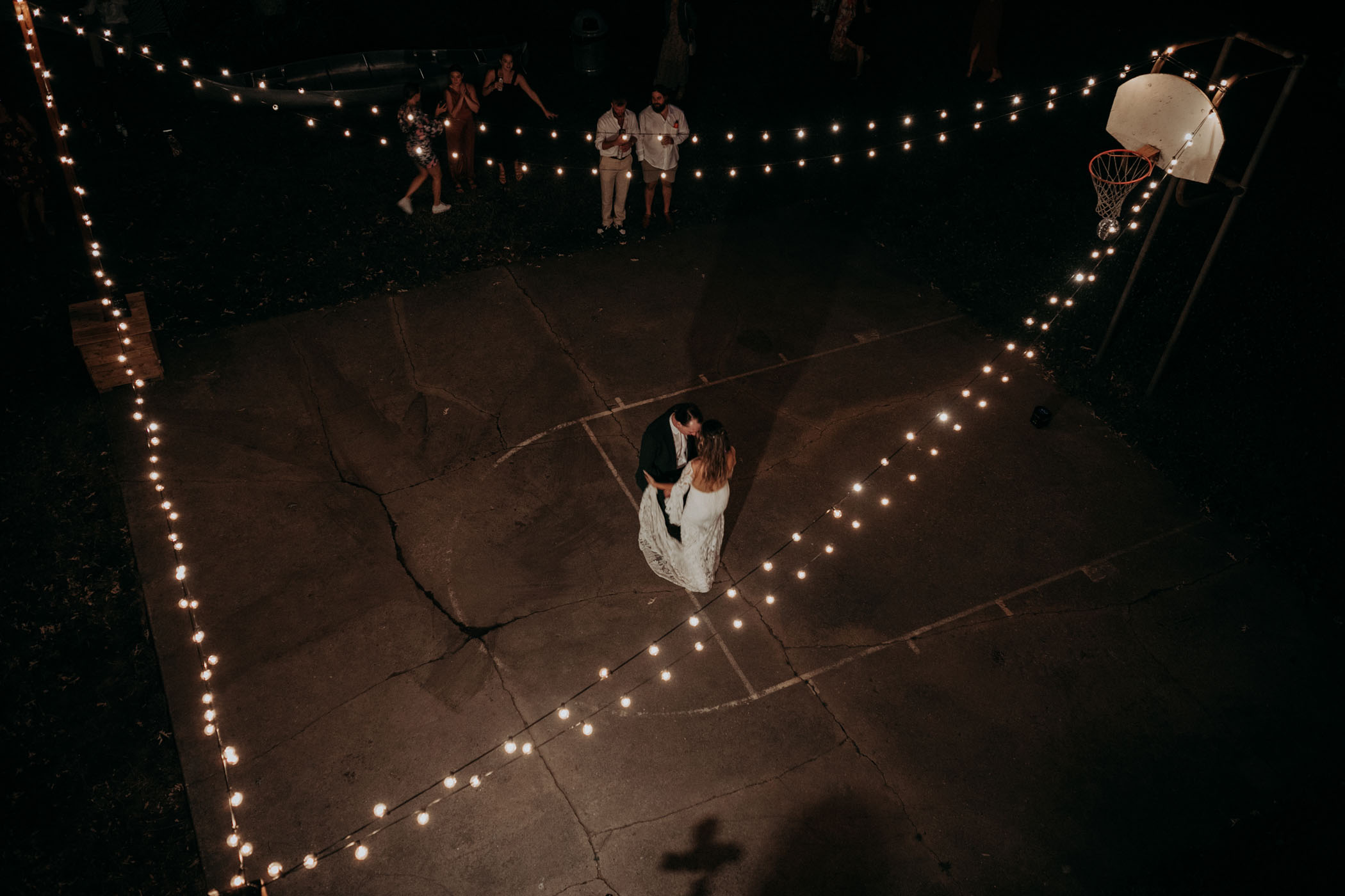Bride and groom dancing on a basketball court