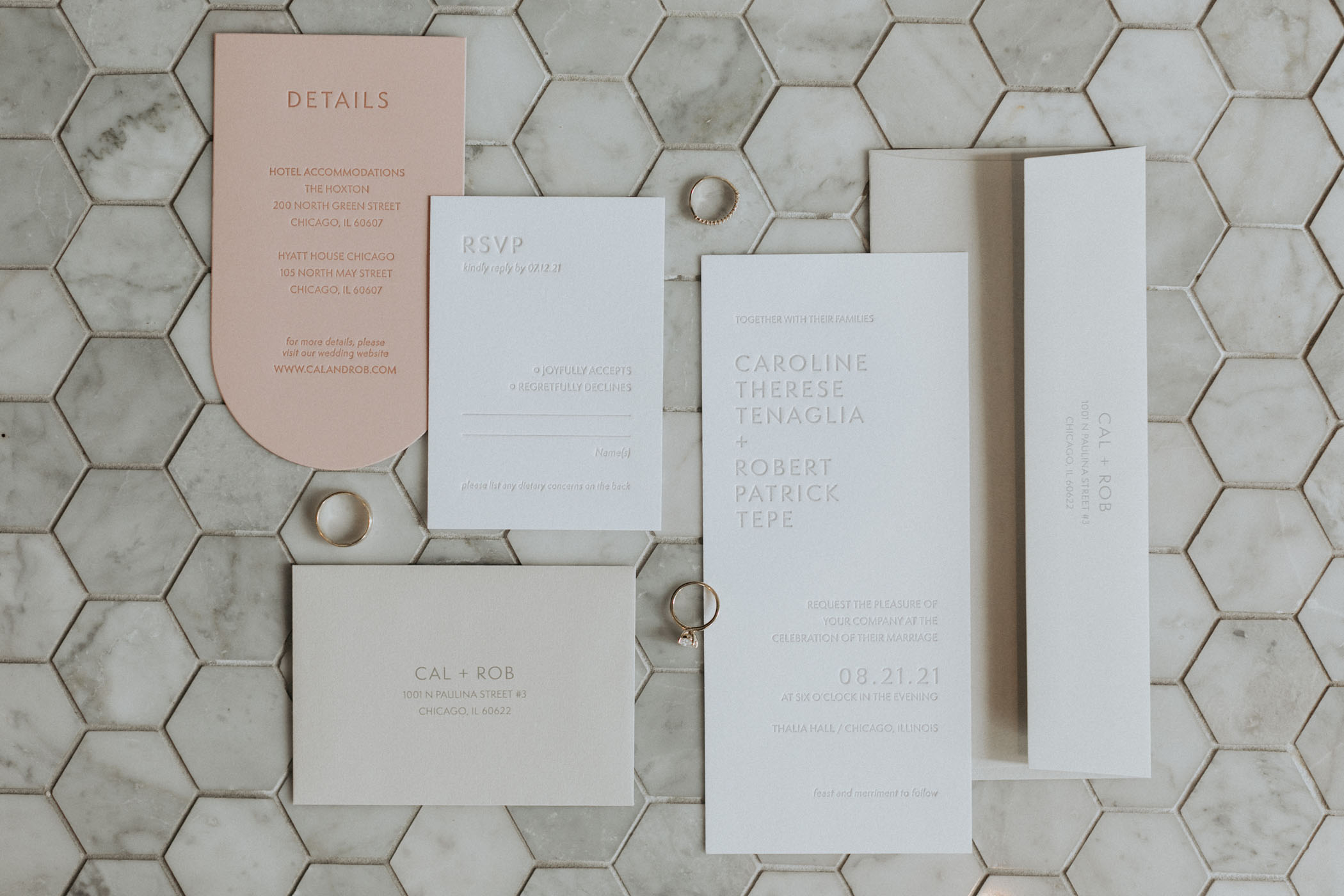 peach and neutral wedding invitations against hexagonal tile
