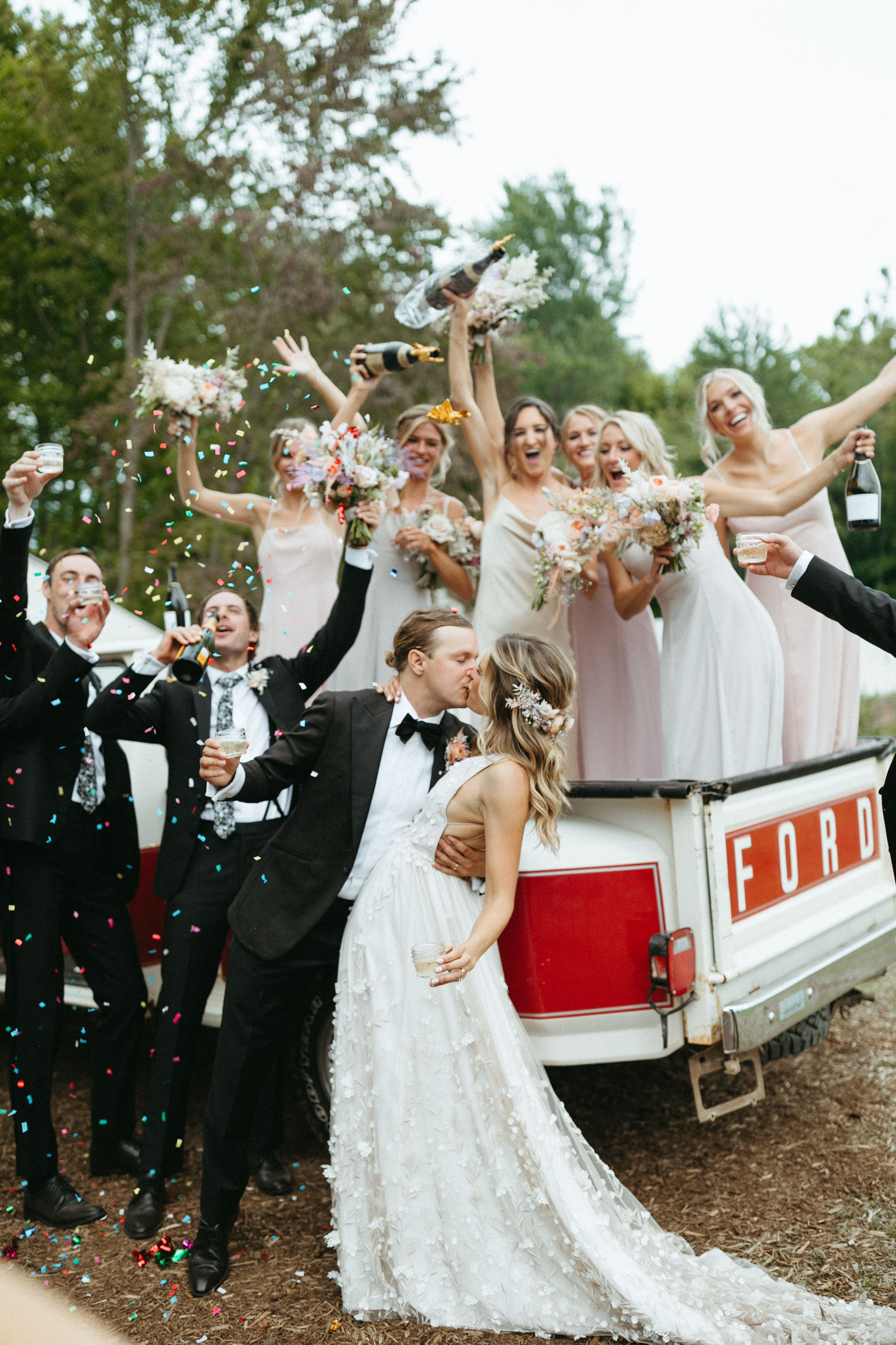bridal party celebrating bride and groom with confetti 