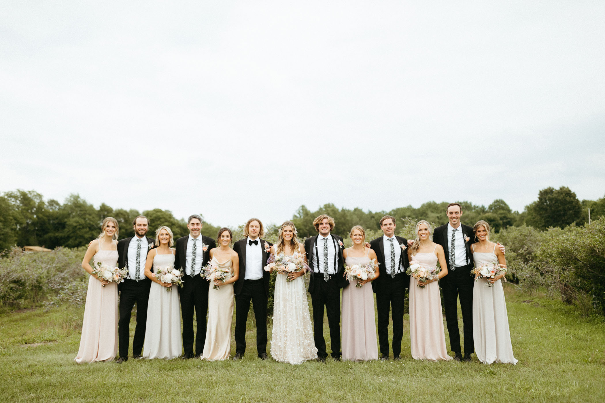 groomsmen and bridesmaids posing in alternating order