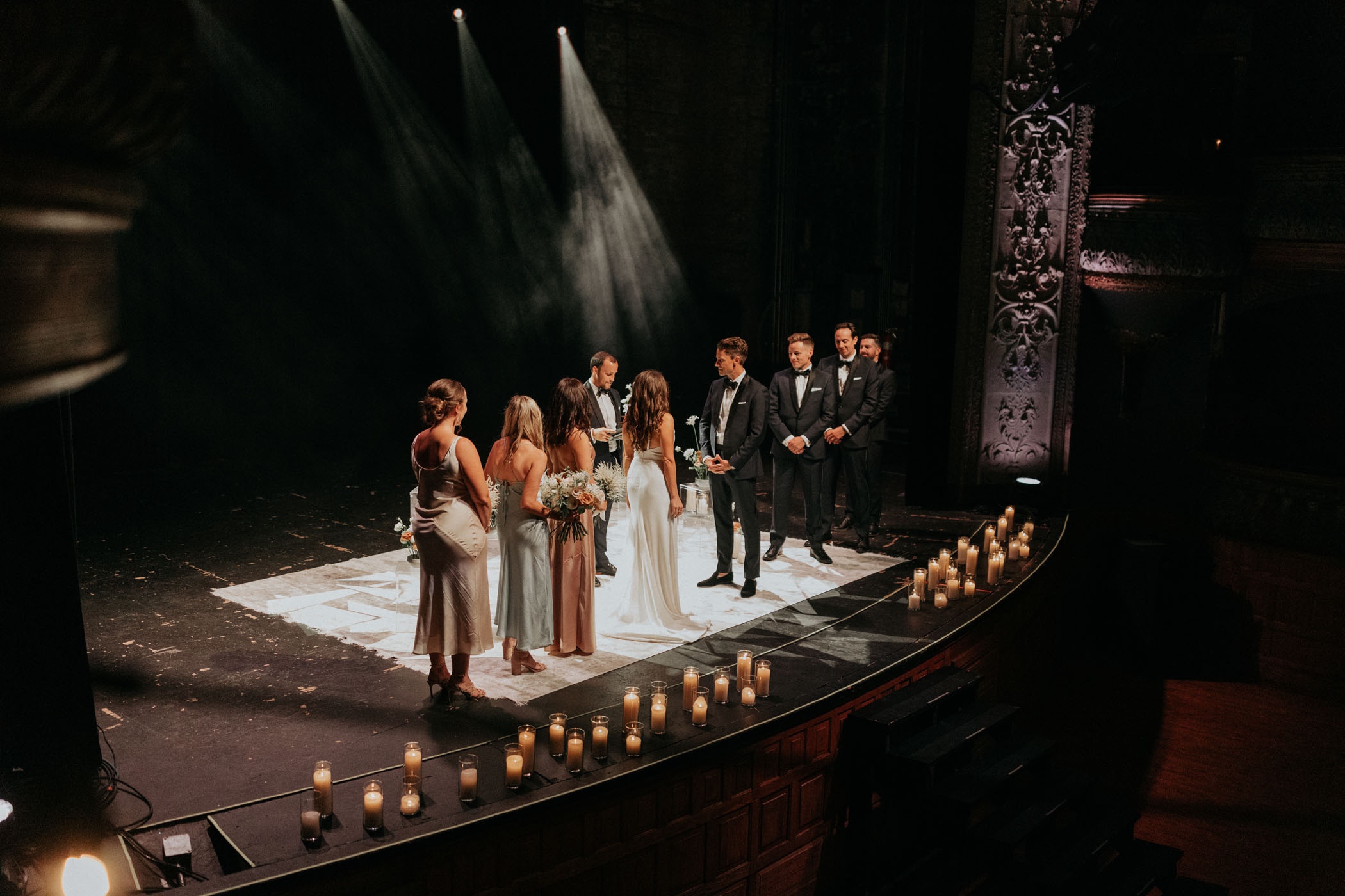 bride and groom saying vows on music hall stage