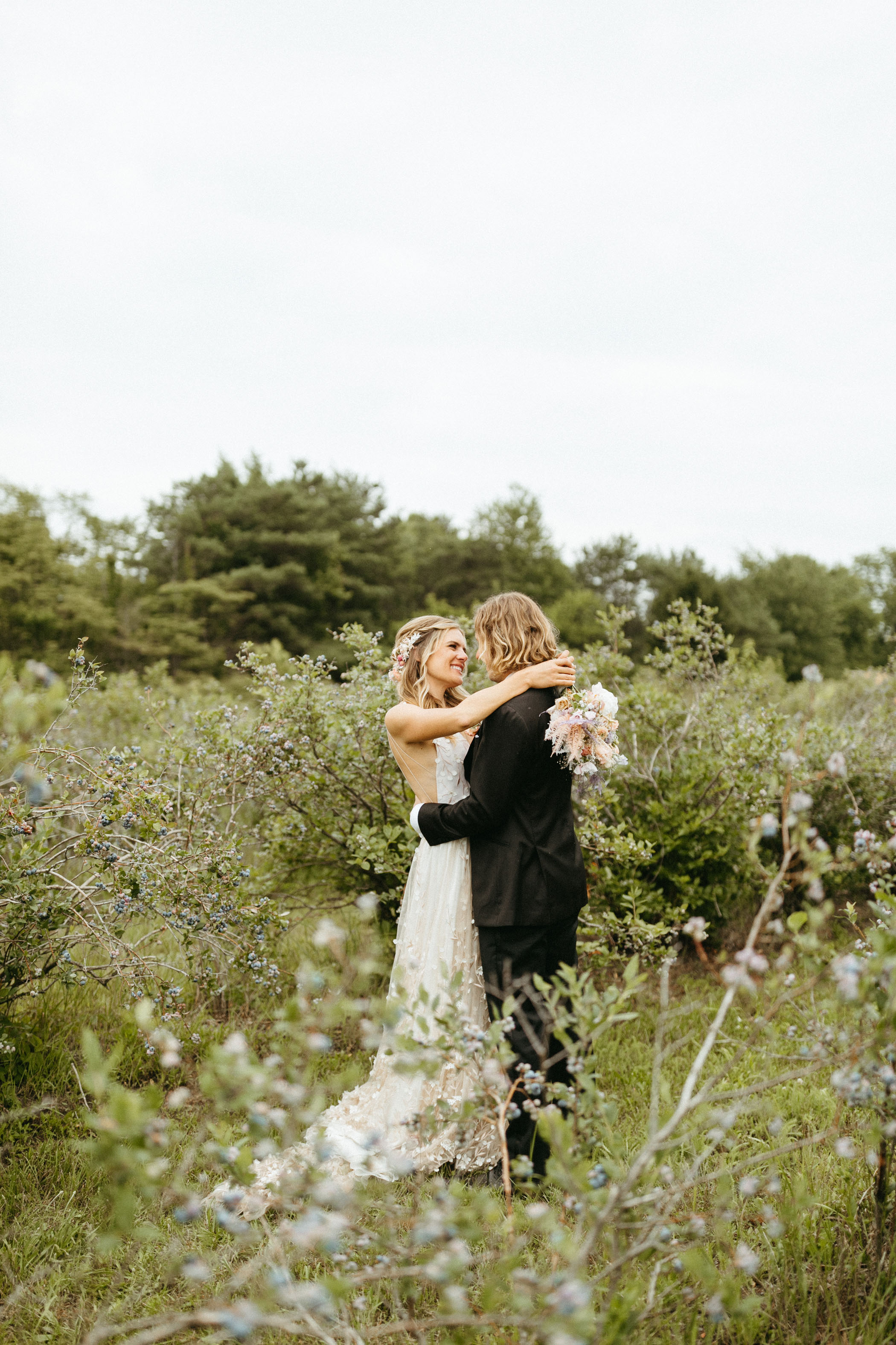 bride and groom hugging in blueberry farm wedding venue