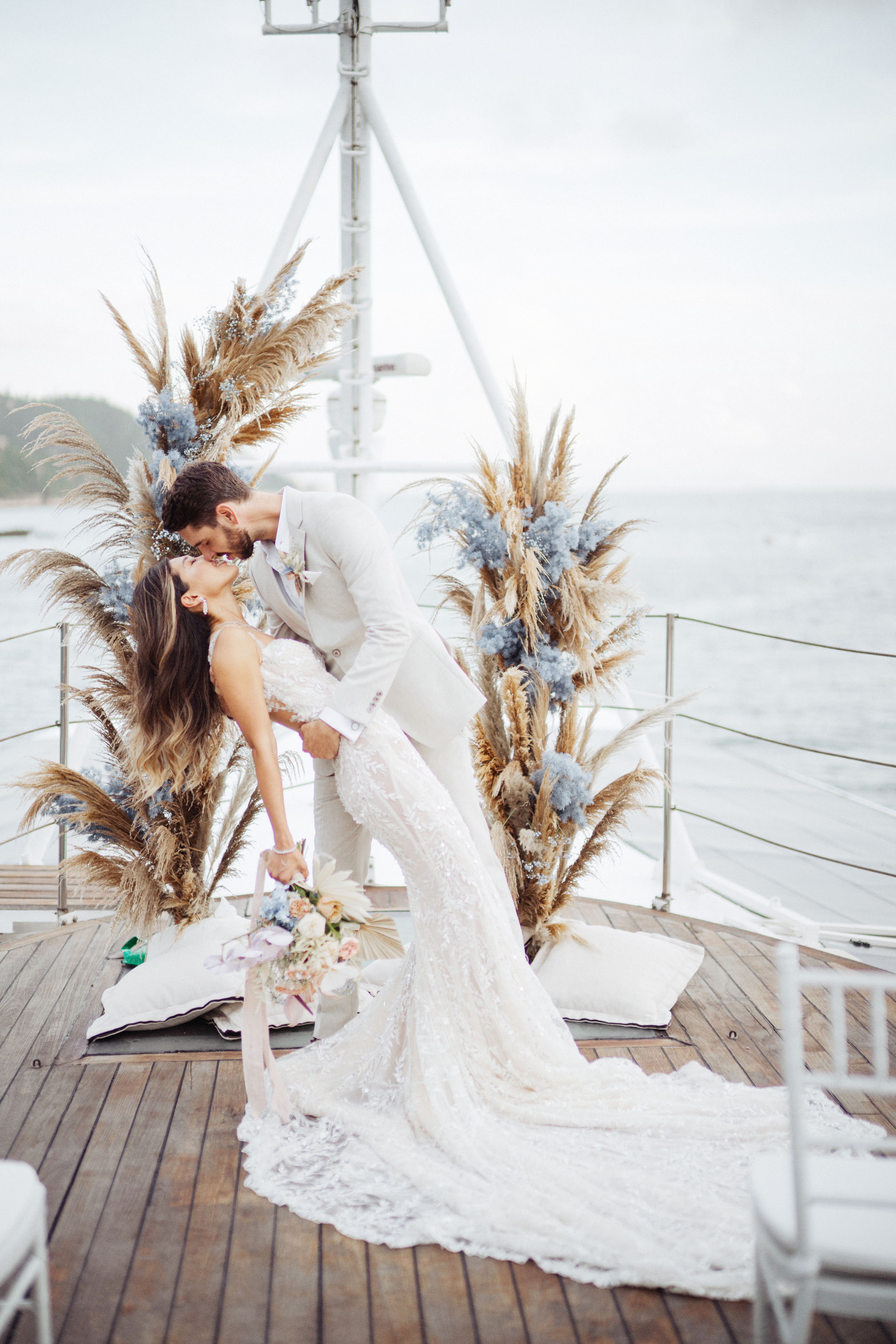 Bride and groom getting first kiss on boat