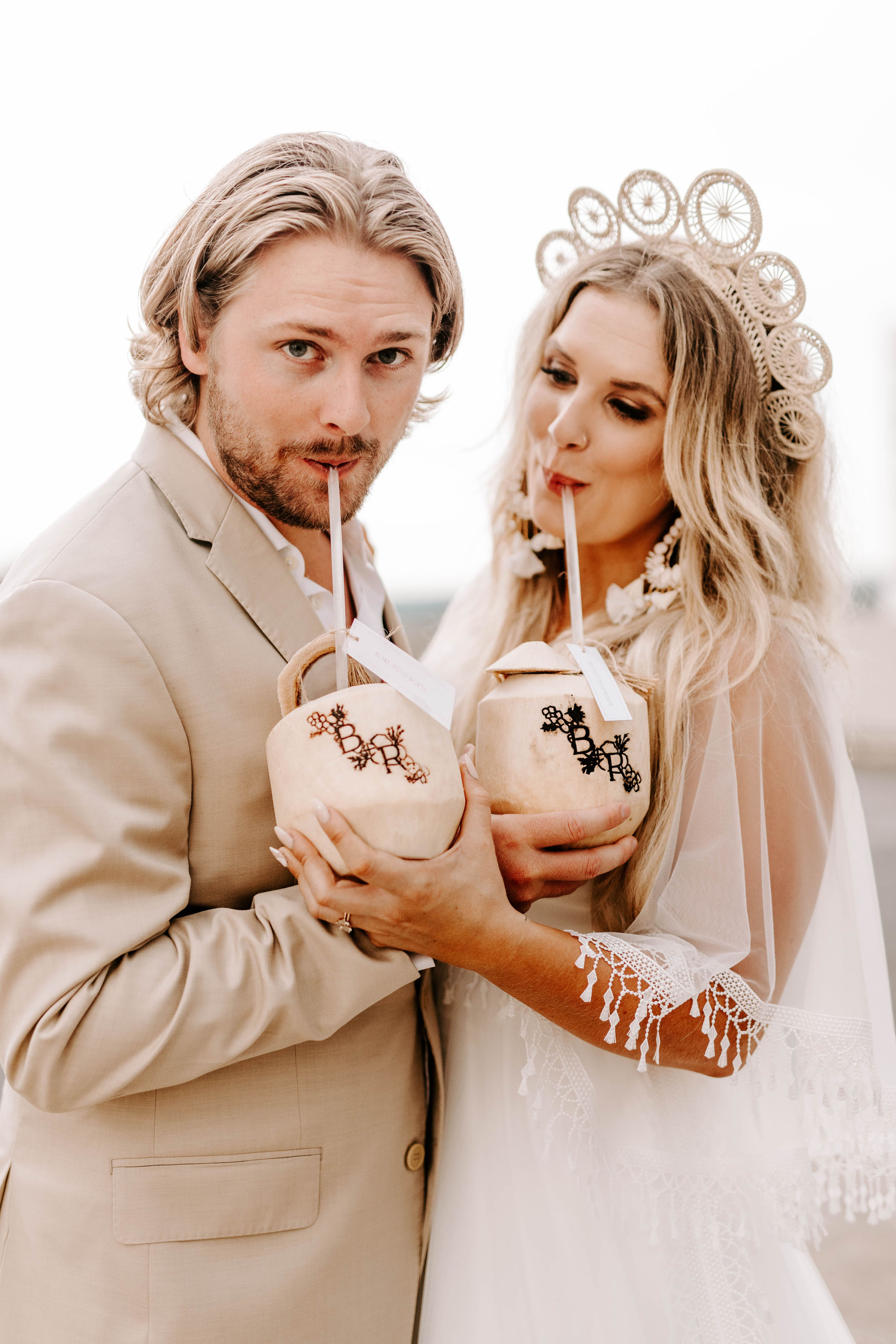 Bride and groom drinking out of monogrammed coconuts