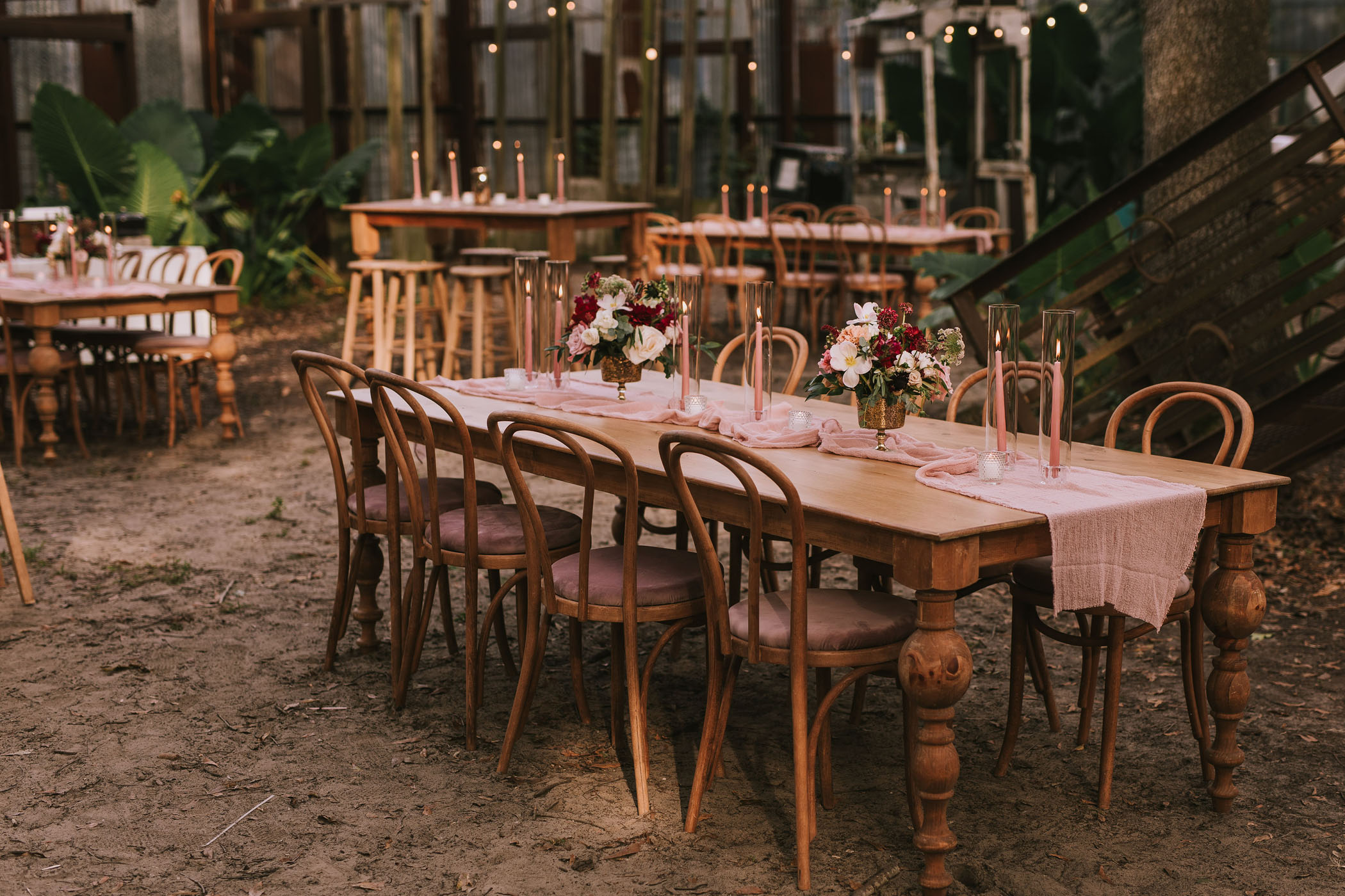 Wooden wedding reception tables with pink decor