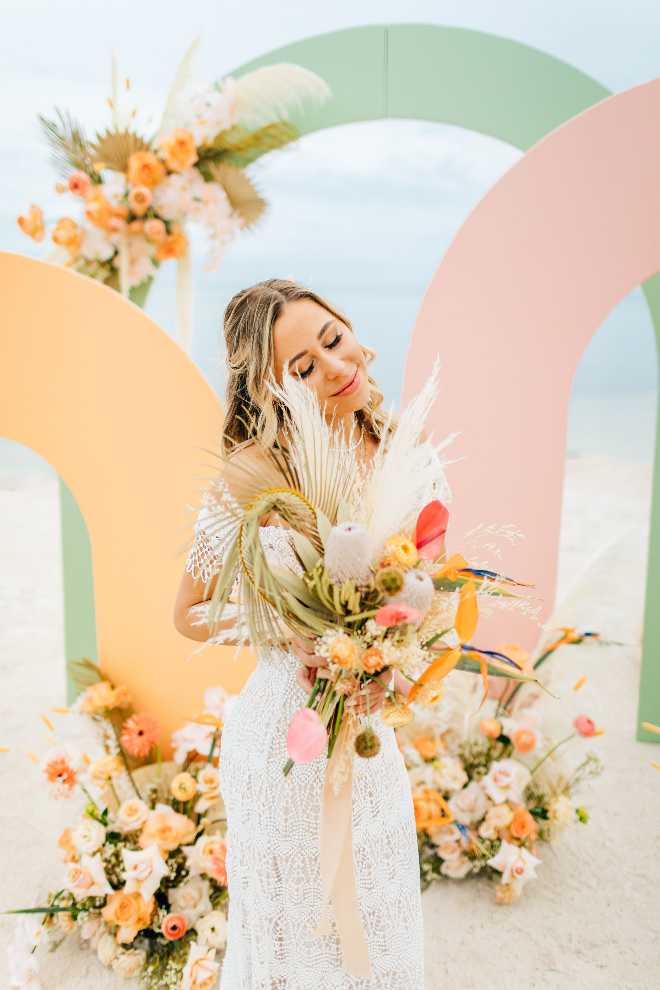 Tropical colored wedding florals and arches