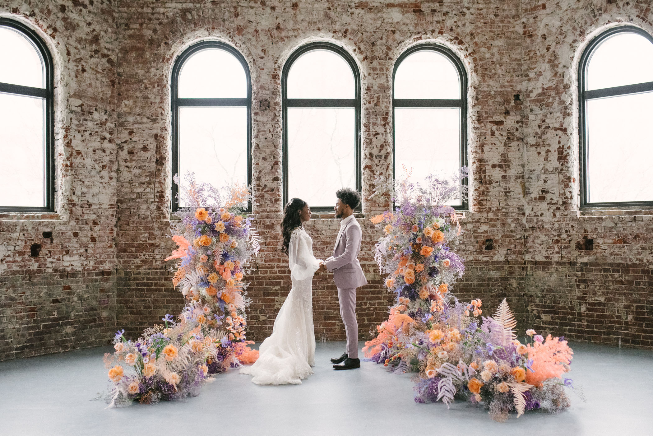 Purple and orange wedding ceremony flowers