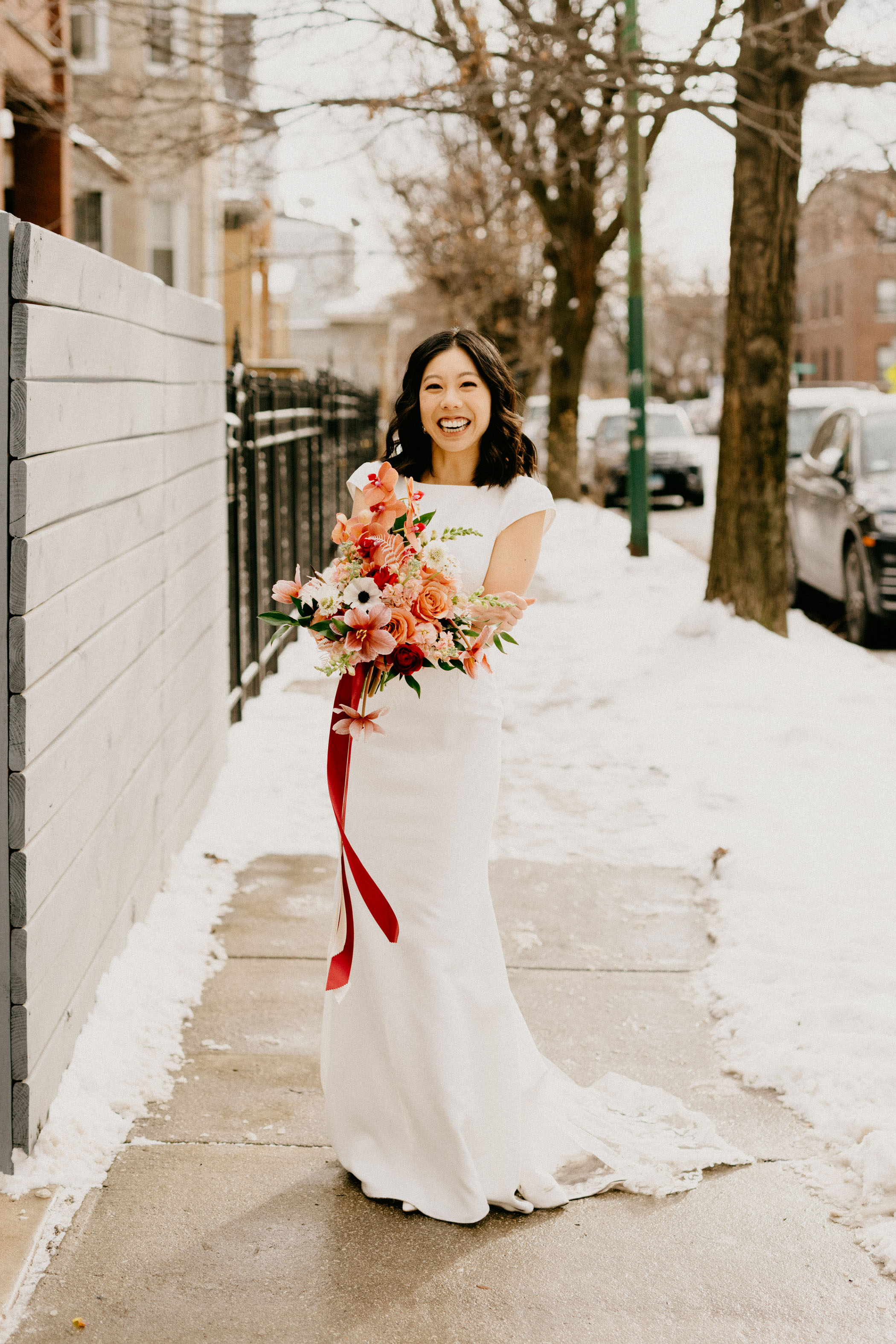 Bride in the snow holding bouquet