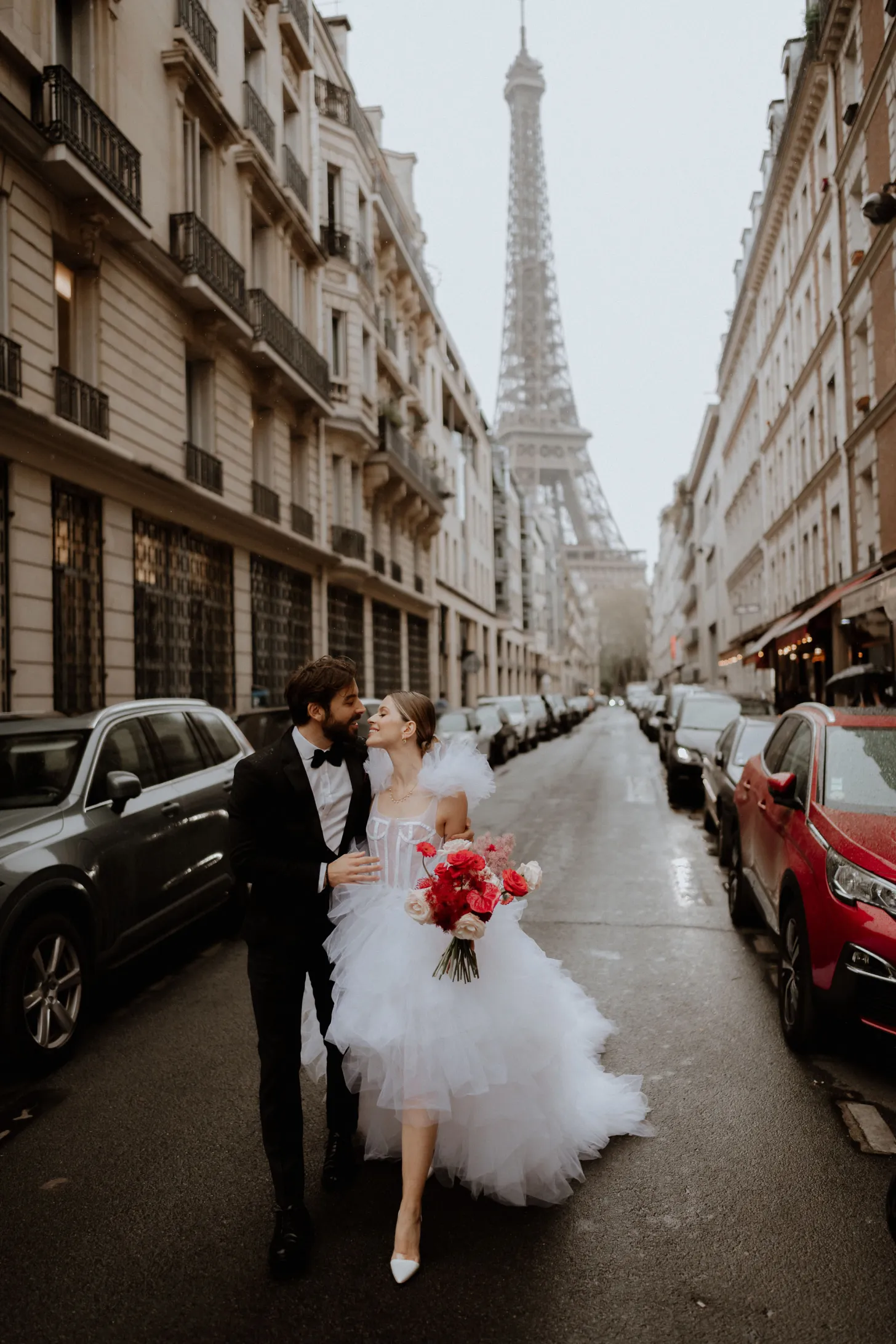 bride and groom wandering the streets of Paris with the Eiffel Tower behind them during their planned couples time on their wedding day
