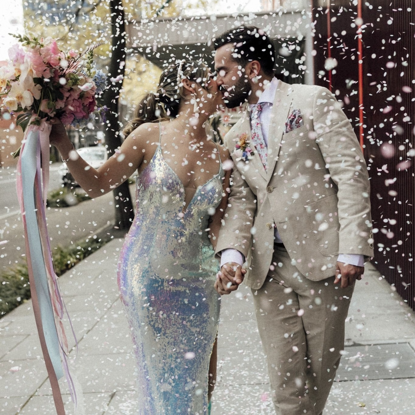 Taylor Swift Lover wedding inspo where the bride is wearing a pastel sequin gown and carrying a colorful rainbow bouquet