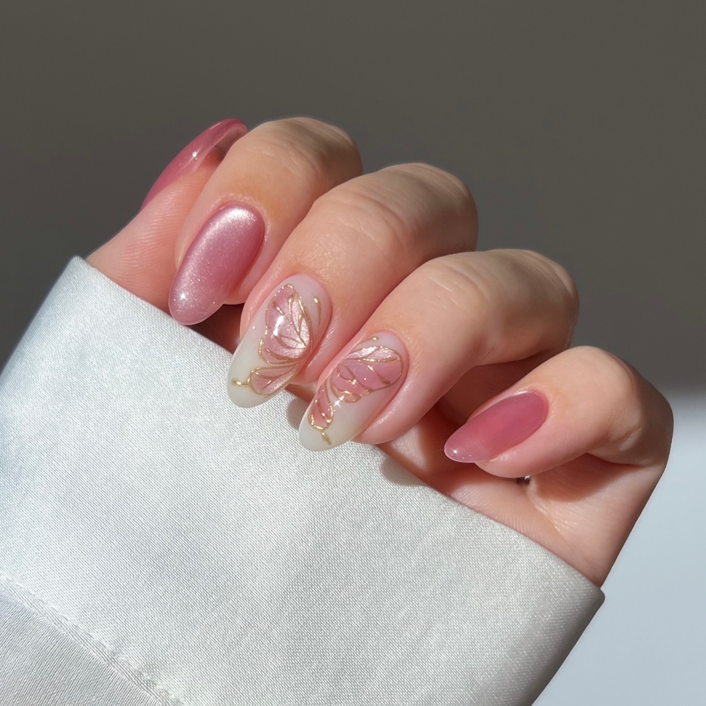 light pink cat eye nails with whimsical nail art designs